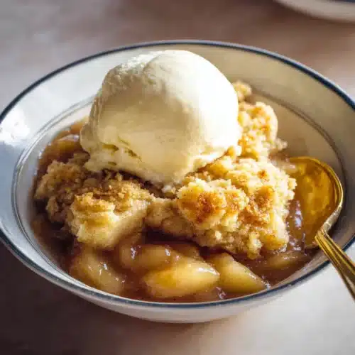 Easy Apple Cobbler Recipe (Perfect for Thanksgiving) 6 Apple cobbler with golden topping and vanilla ice cream in a bowl