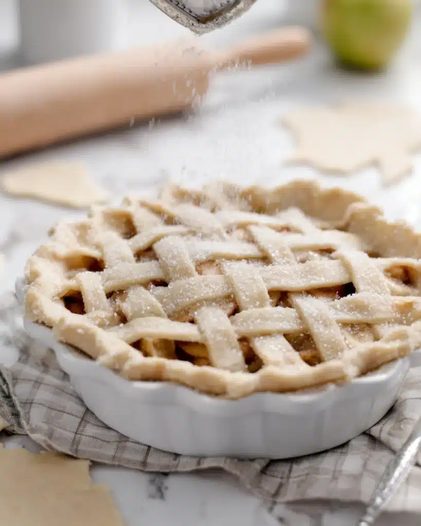 Sprinkling sugar on unbaked lattice apple pie crust