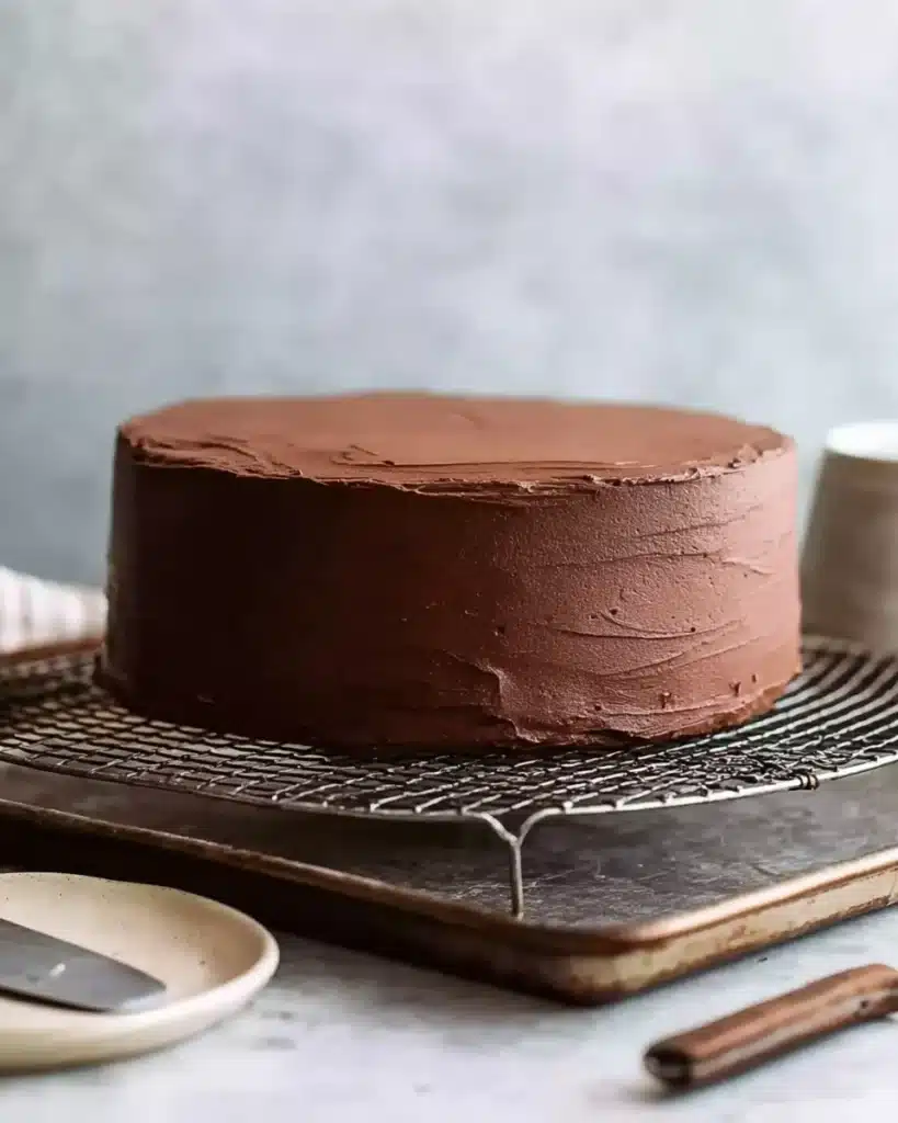 Chocolate Mirror Glaze (Thanksgiving Recipe) 3 Chocolate cake frosted with ganache on wire rack before glazing