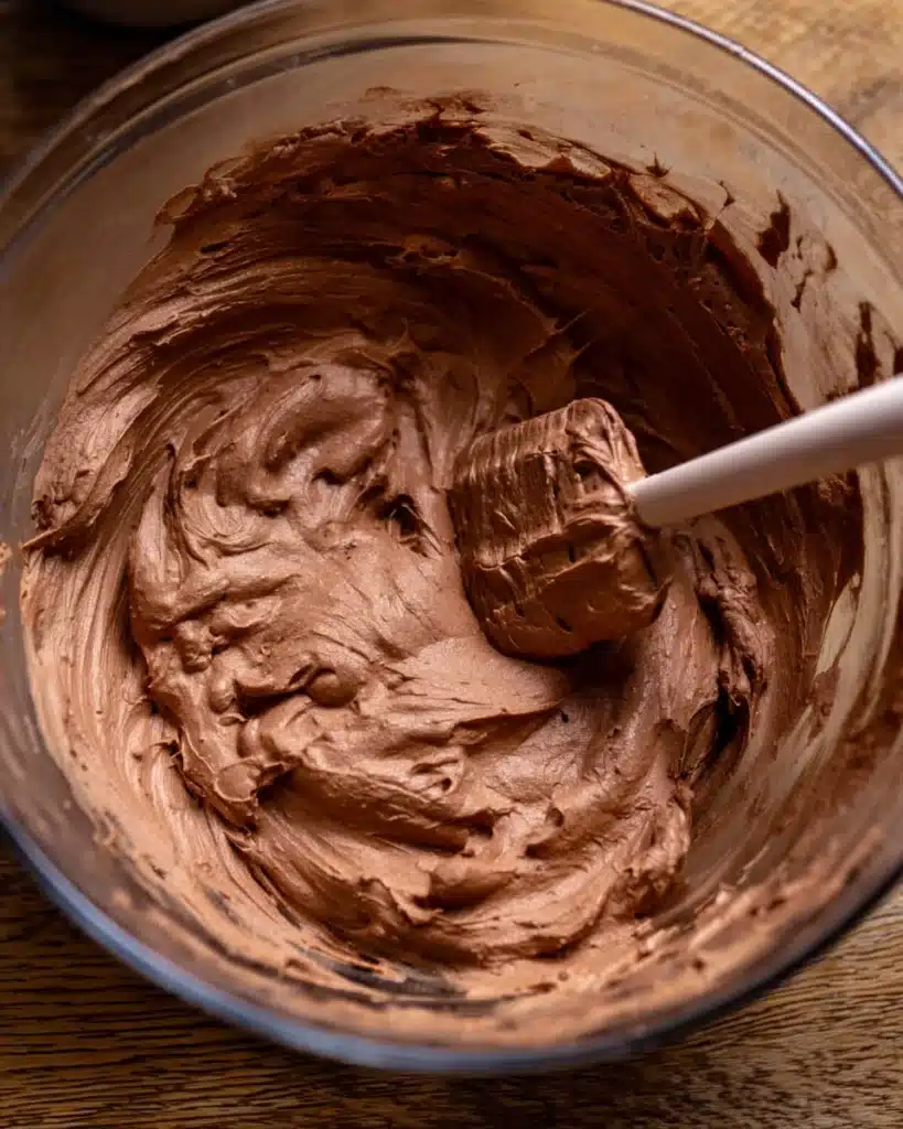 Chocolate Peanut Butter Pie (Thanksgiving Favorite) 3 Chocolate peanut butter pie filling being mixed in a glass bowl with spatula