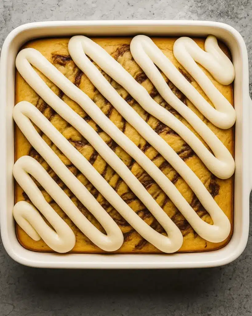 Cinnamon Roll Cake with Cream Cheese Frosting | Perfect Thanksgiving Dessert 5 Baked Cinnamon Roll Cake with Cream Cheese Frosting piped on top