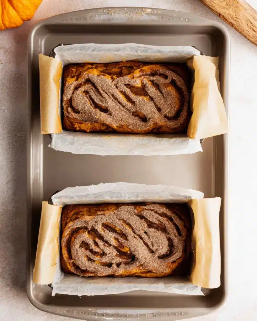 Pumpkin bread batter in loaf pans with cinnamon sugar swirl topping