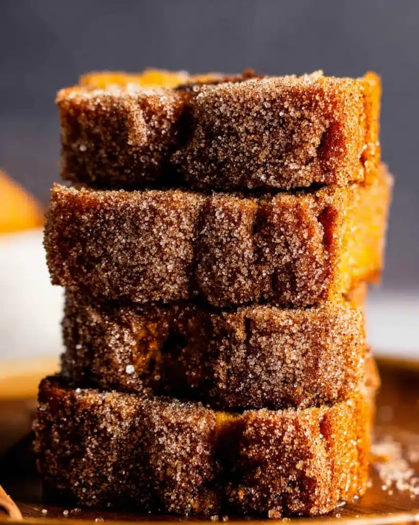 Stack of sliced cinnamon swirl pumpkin bread with sugar topping