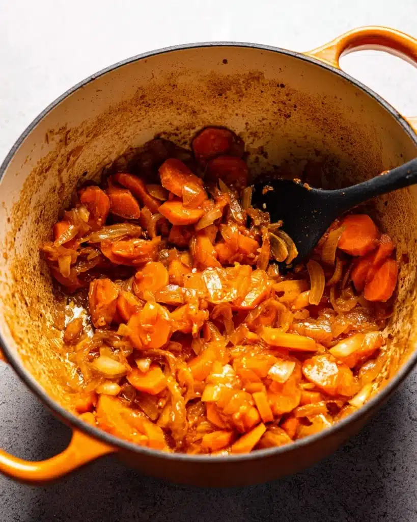 Classic Beef Bourguignon (Christmas Recipe) 4 Carrots and onions sautéing in Dutch oven for classic beef bourguignon