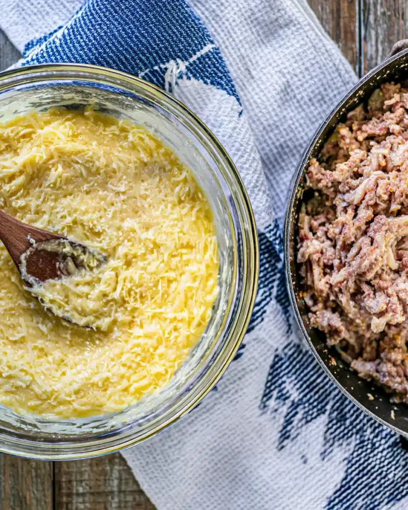 Easy Sausage Pancake Bites 2 Glass bowl of cheesy pancake batter beside skillet of browned sausage for Easy Sausage Pancake Bites