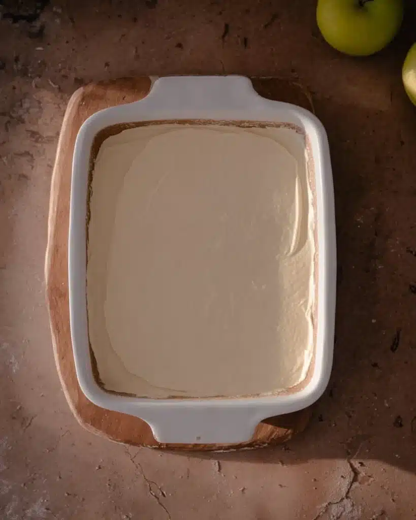 Easy caramel apple cheesecake dip recipe 4 Cheesecake base spread in white dish for easy caramel apple cheesecake dip recipe