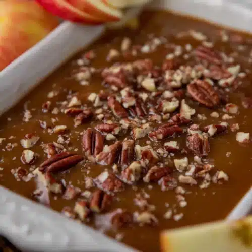 Easy caramel apple cheesecake dip recipe 8 Caramel apple cheesecake dip topped with pecans in a white dish