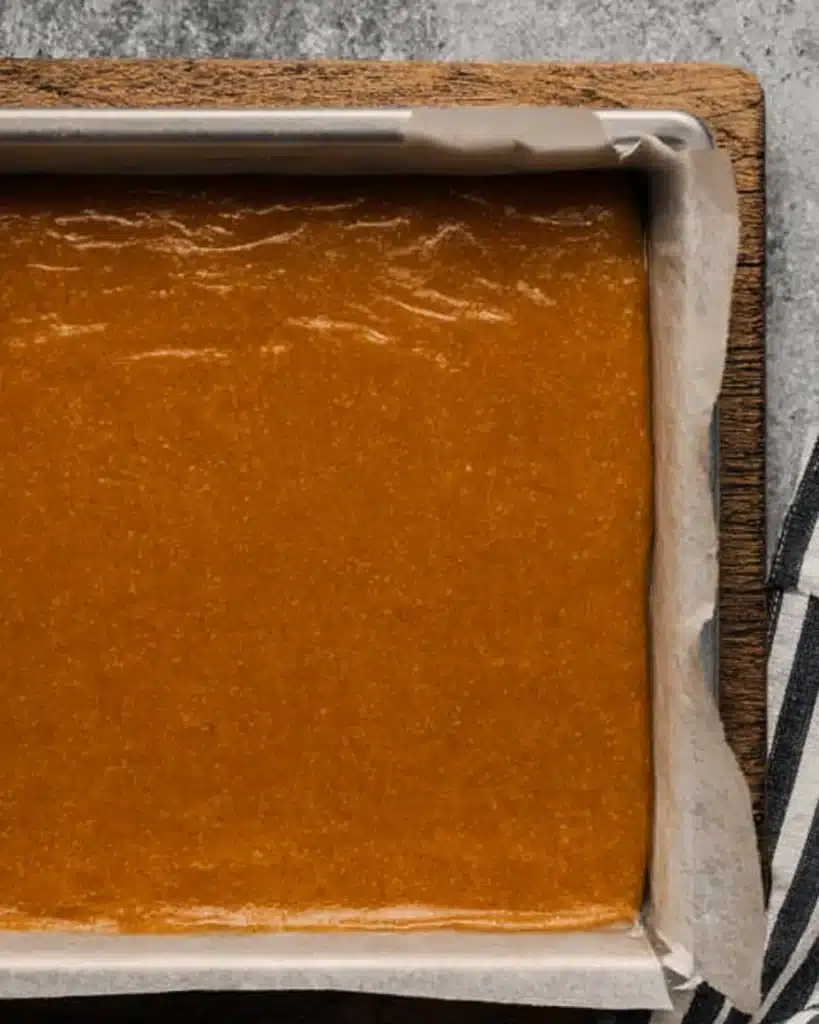 Fall Pumpkin Spice Roll Cake (Perfect Thanksgiving Dessert) 4 Pumpkin spice roll cake batter spread evenly in a parchment-lined jelly roll pan