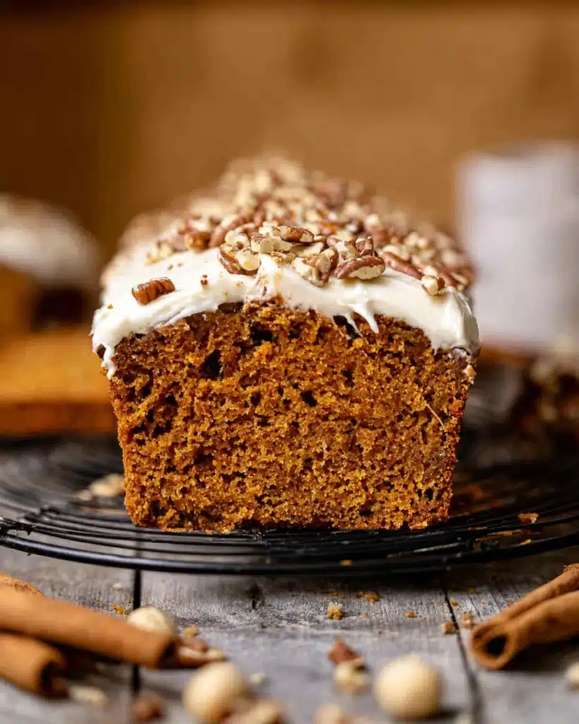 Frosted Pumpkin Bread 9 Close-up of sliced frosted pumpkin bread with cream cheese frosting and pecans