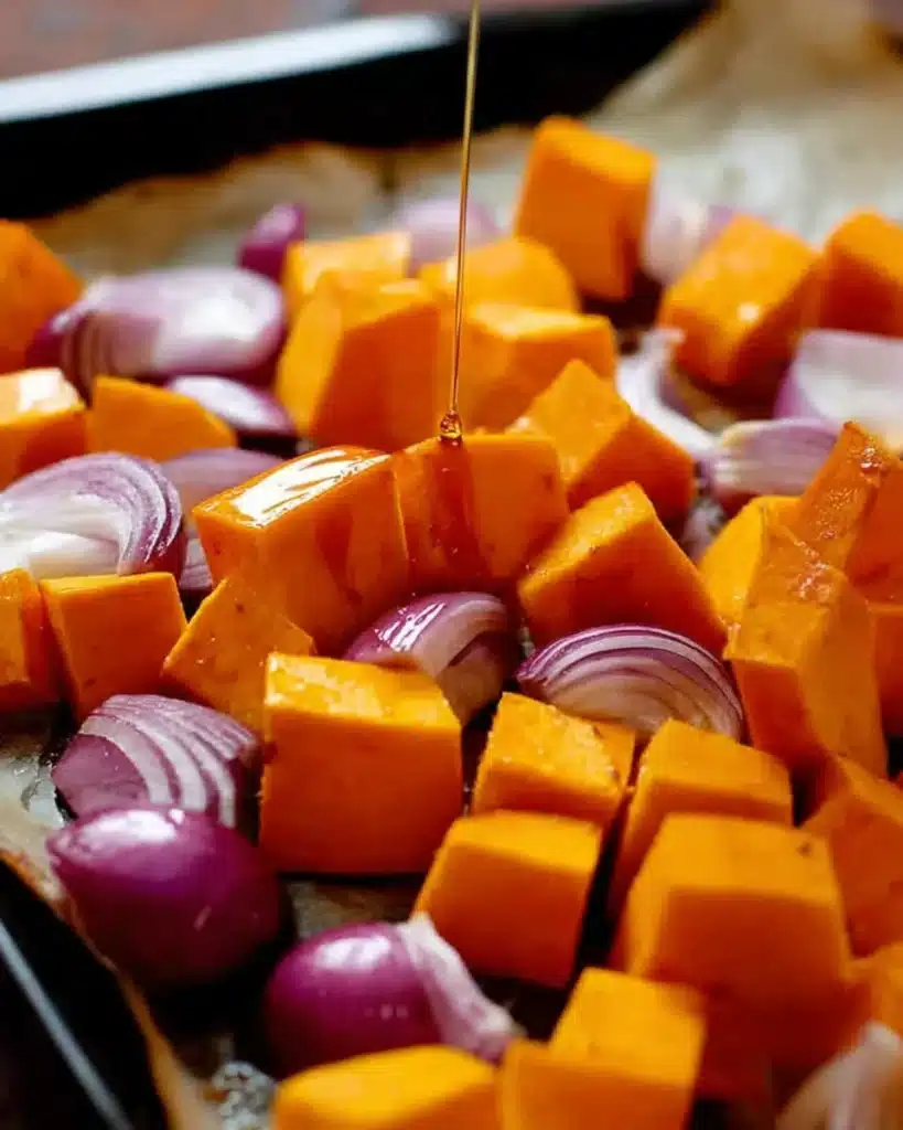Pumpkin cubes and red onion with maple syrup drizzle before roasting