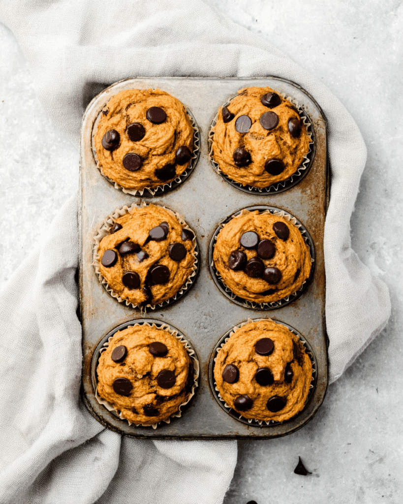 Pumpkin Chocolate Chip Protein Muffins 4 Freshly baked pumpkin chocolate chip protein muffins in muffin tin