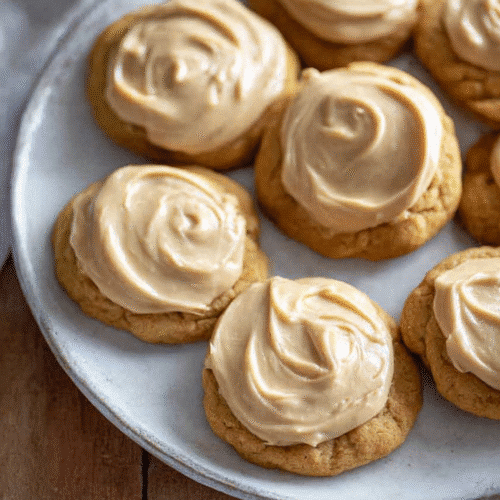 Pumpkin Cookies with Caramel Frosting | Best Cozy Thanksgiving Dessert 6 Pumpkin cookies with caramel frosting on a plate, soft and frosted