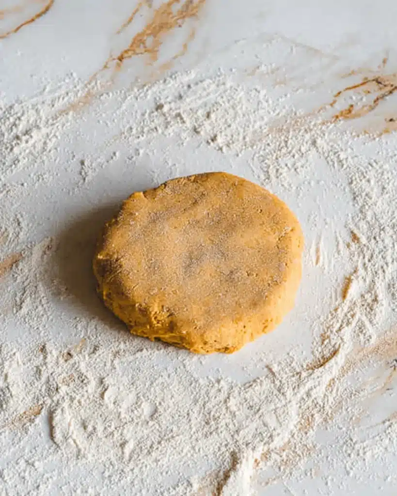 Pumpkin Scones Recipe – Perfect Fall Treat 7 Pumpkin scone dough shaped into a round disc on floured surface