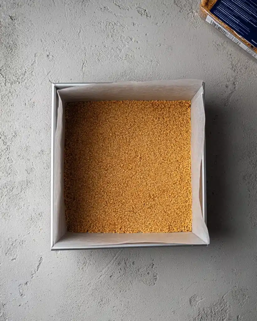 The Best Pumpkin Cheesecake Bars Ever 3 Pressed graham cracker crust in baking pan for cheesecake bars