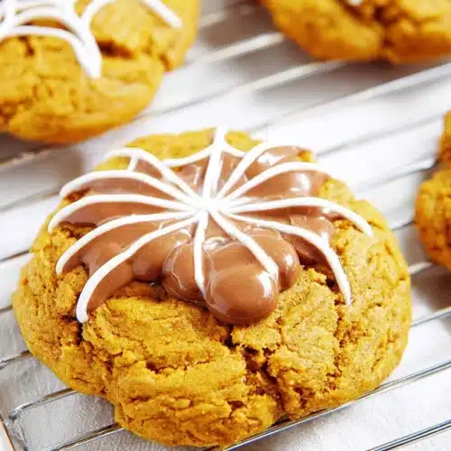 Spiced Pumpkin Cookies for Halloween 7 Halloween spiced pumpkin cookie with chocolate spiderweb decoration on a cooling rack
