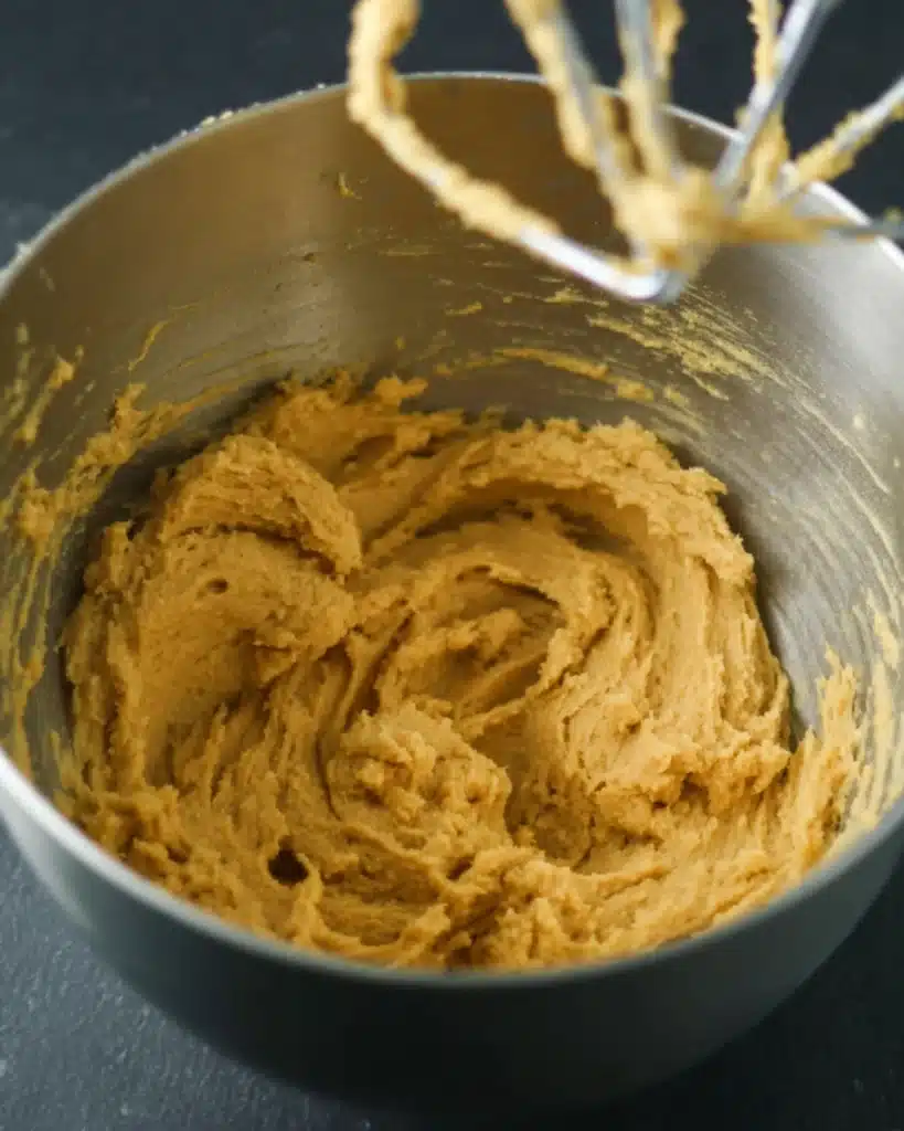 Spiced Pumpkin Cookies for Halloween 4 Pumpkin cookie dough in a mixing bowl with mixer beaters above