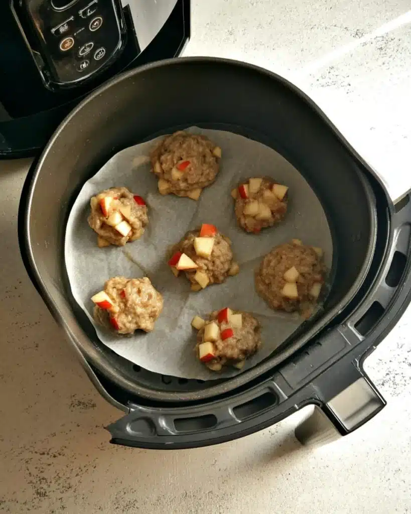 Air Fryer Apple Fritters Recipe – Quick, Easy & Delicious 4 Raw apple fritter batter in air fryer basket on parchment paper