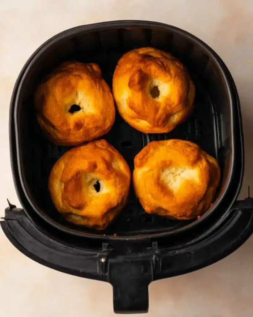 Air Fryer Biscuit Donuts – Quick, Easy, and Irresistibly Fluffy 4 Golden brown air fryer biscuit donuts freshly cooked in basket