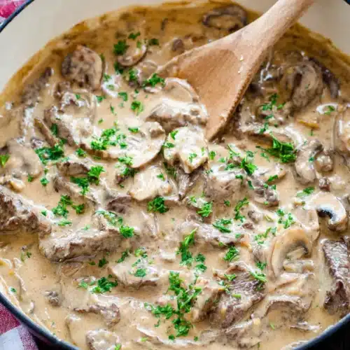 Beef Stroganoff Recipe 6 Creamy beef stroganoff with mushrooms in a skillet topped with fresh herbs