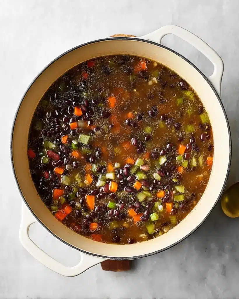 Black Bean Soup 4 Dutch oven filled with simmering black bean soup with vegetables and broth