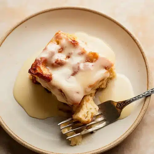 Bread Pudding with Vanilla Sauce 10 Bread pudding with vanilla sauce on a plate with a fork