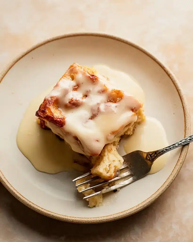 Bread Pudding with Vanilla Sauce 1 Bread pudding with vanilla sauce on a plate with a fork
