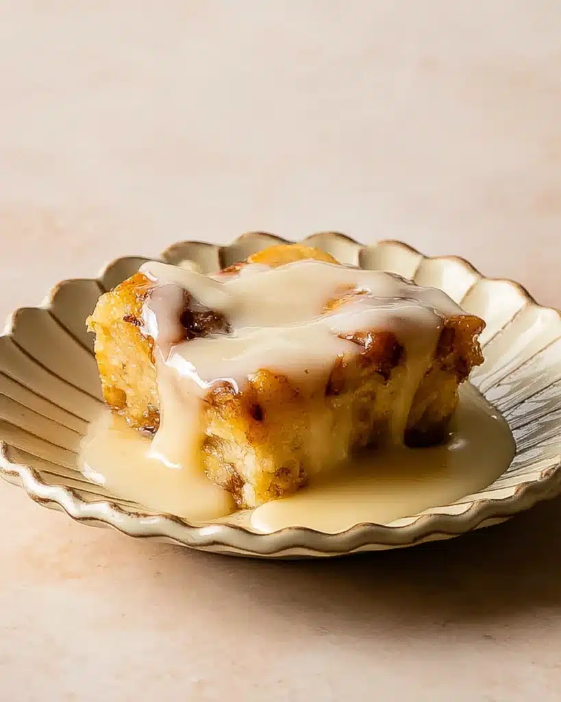 Bread Pudding with Vanilla Sauce 9 Single slice of bread pudding with vanilla sauce on a plate