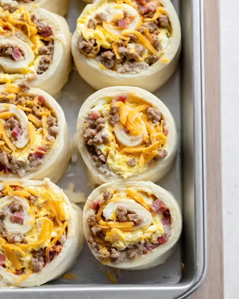 Breakfast Rolls 10 Unbaked breakfast rolls filled with eggs, sausage, and cheese in a pan