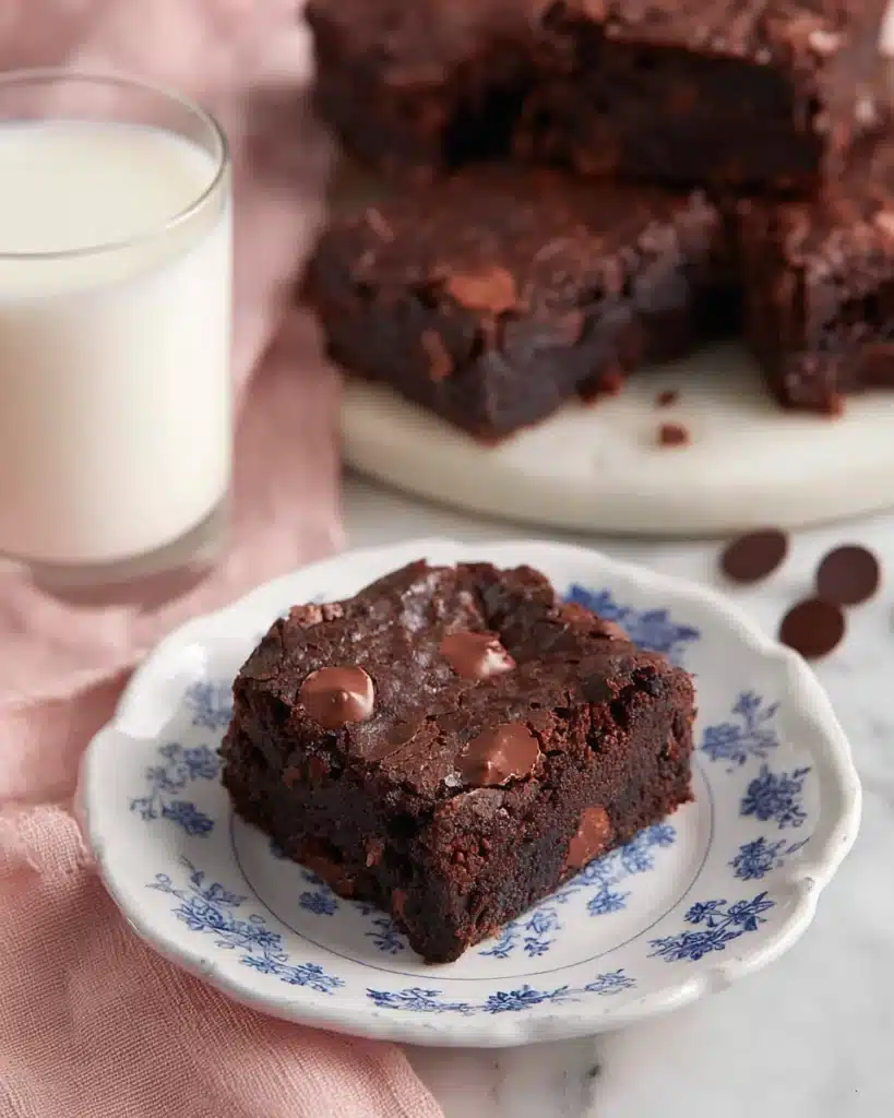 Brownie Recipe (Best Fudgy & Chewy Brownies Ever) 1 Fudgy chocolate brownie on blue floral plate with milk glass