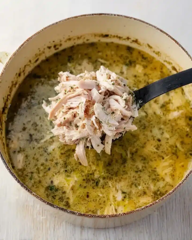 Chicken Vegetable Soup 6 Shredded chicken being added to simmering chicken vegetable soup in a pot