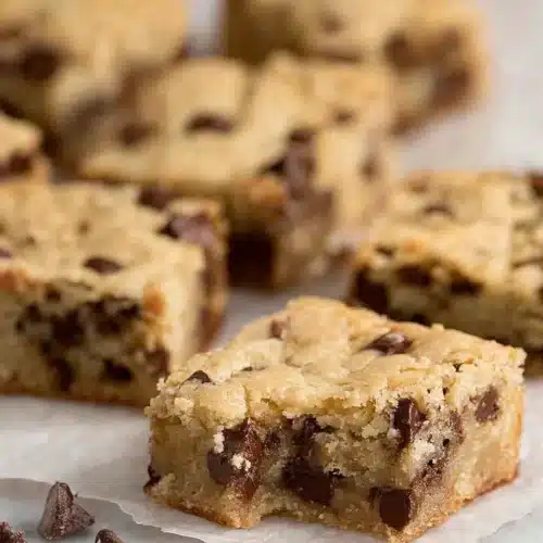 Chocolate Chip Cookie Bars – Soft, Chewy, and Totally Irresistible 6 Chewy golden chocolate chip cookie bars on parchment paper
