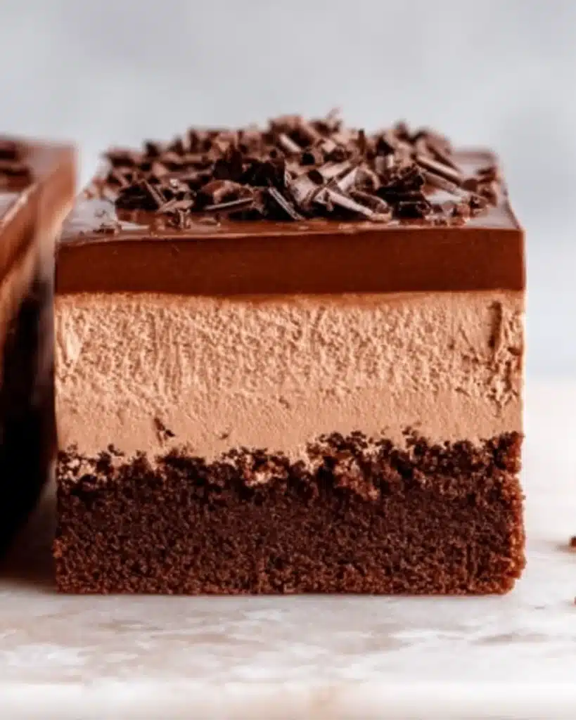 Close-up of chocolate mousse brownie slice with ganache topping