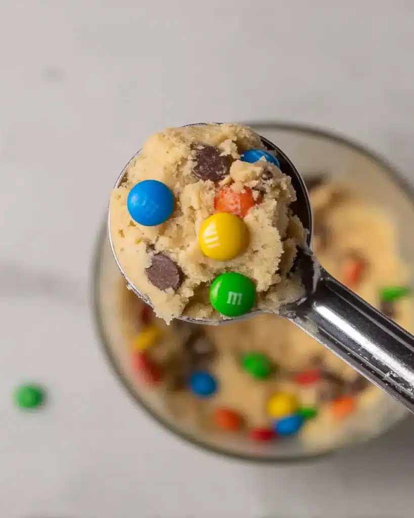 Crumbl Monster Cookie Recipe – Soft & Packed with M&M’s 4 Crumbl Monster cookie dough scoop with M&M’s and chocolate chips