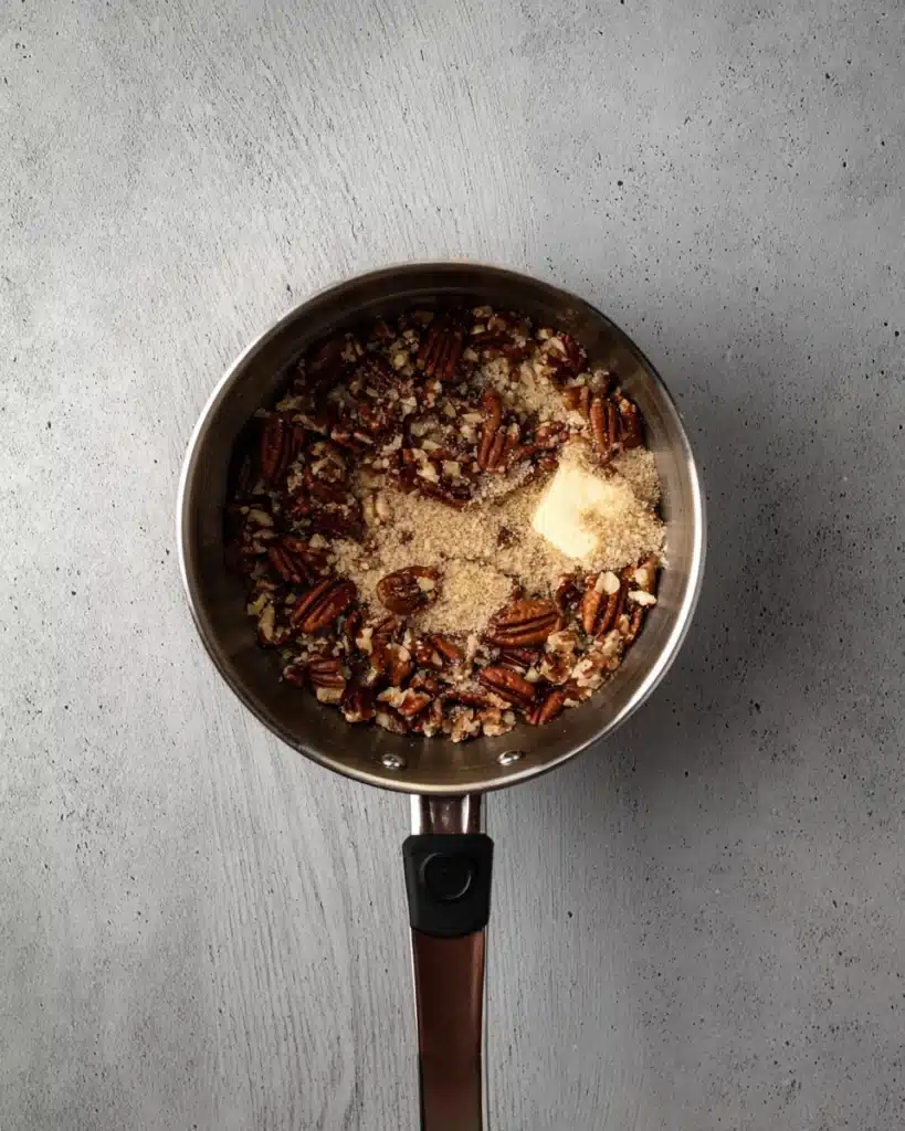 Crumbl Pecan Pie Cookie Recipe 4 Pecan pie filling ingredients with butter, brown sugar, and chopped pecans in saucepan