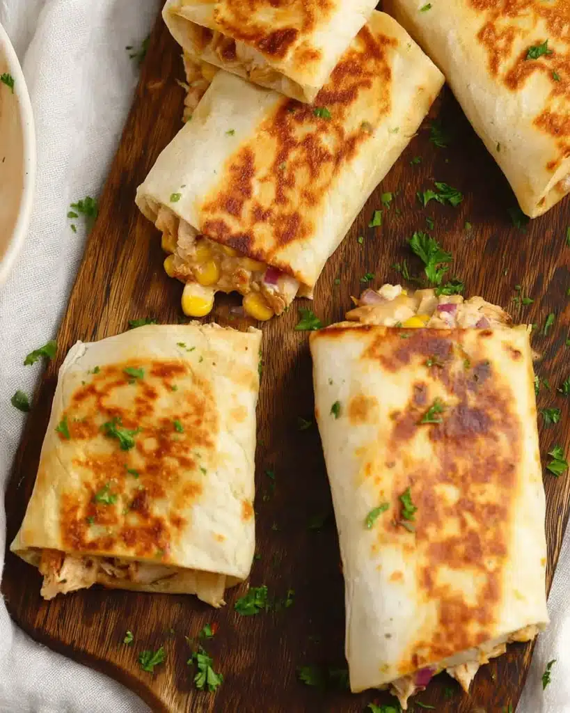 Easy Chicken Wraps (Quick & Flavorful Lunch Recipe) 6 Crispy easy chicken wraps with melted cheese and corn on wooden board