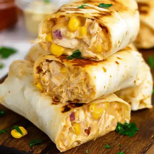 Easy Chicken Wraps (Quick & Flavorful Lunch Recipe) 7 Grilled easy chicken wraps with cheese, corn, and shredded chicken on wooden board