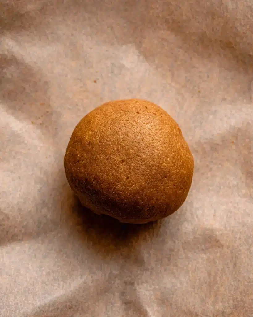 Gingerbread Cheesecake Cookies 5 Smooth gingerbread cheesecake cookie dough ball on parchment paper