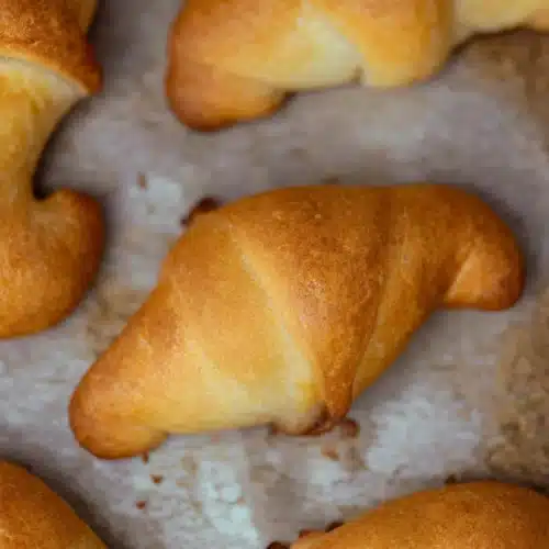 Ground Beef Crescent Rolls 5 Golden brown ground beef crescent rolls on parchment paper