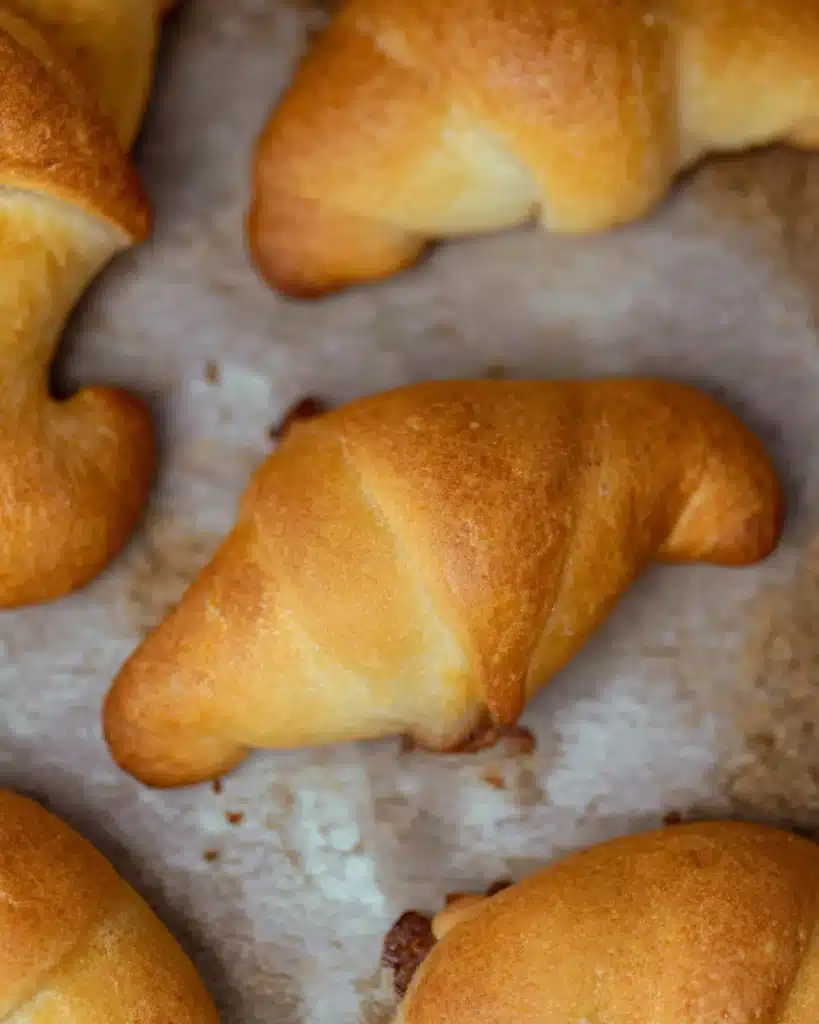 Ground Beef Crescent Rolls 1 Golden brown ground beef crescent rolls on parchment paper