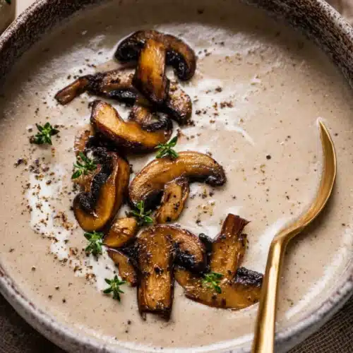 Mushroom Bisque 7 Creamy mushroom bisque topped with sautéed mushrooms and thyme in a rustic bowl