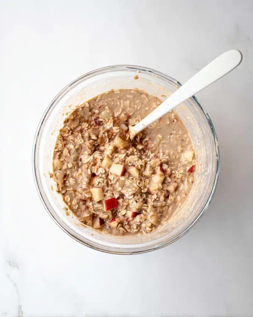 Oatmeal Apple Breakfast Bake batter with oats and apples in a glass bowl