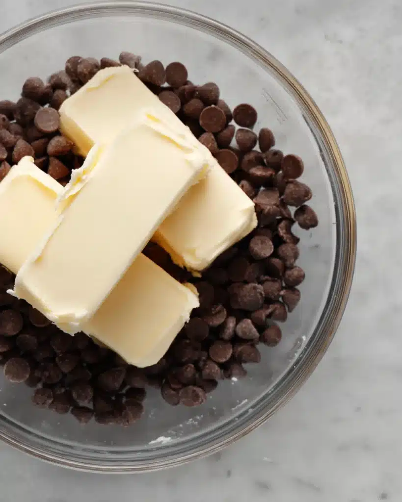 Butter and chocolate chips in a glass bowl ready to melt for brownies