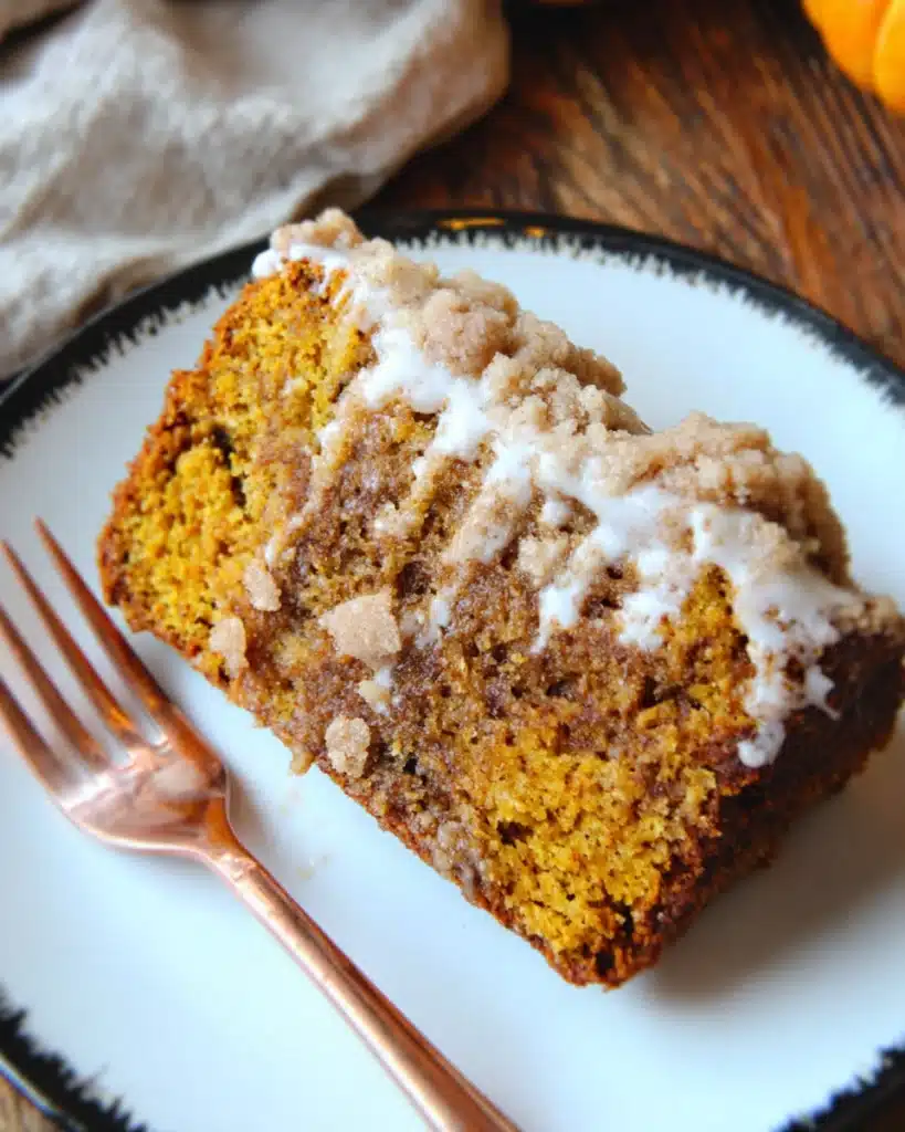 Pumpkin Streusel Bread 3 Slice of pumpkin streusel bread with crumbly topping and maple glaze on white plate
