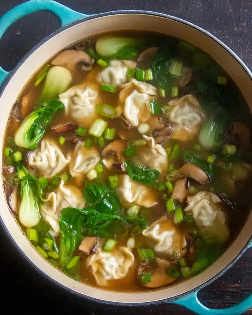 Quick & Easy Wonton Soup Recipe 5 Garnished wonton soup with mushrooms, bok choy, and scallions in broth