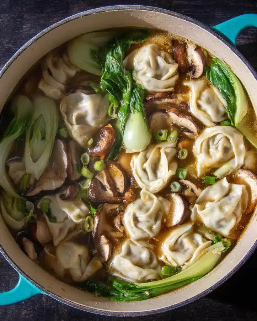 Quick & Easy Wonton Soup Recipe 4 Simmering wonton soup with mushrooms and bok choy in broth