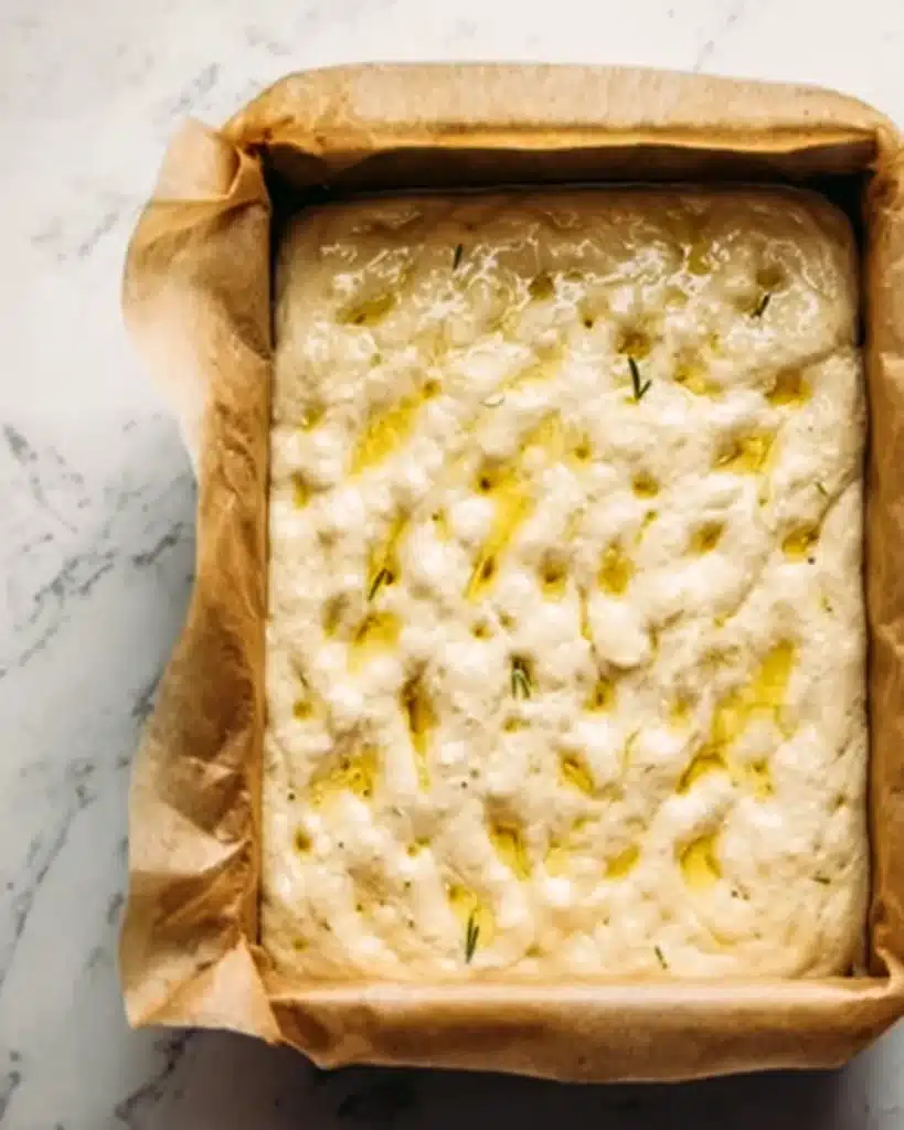 Quick and Dirty Focaccia 5 Focaccia dough dimpled and drizzled with olive oil in baking pan