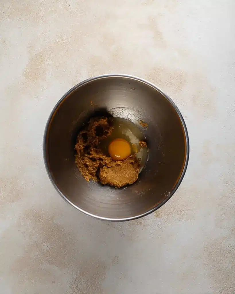Red Velvet Blossoms Cookies – Soft, Sweet, and Perfectly Festive 3 Mixing red velvet cookie dough with egg yolk in a metal bowl