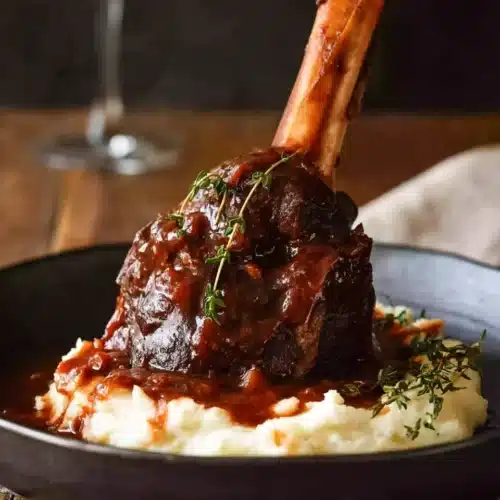 Slow cooked lamb shank in red wine sauce served over creamy mashed potatoes