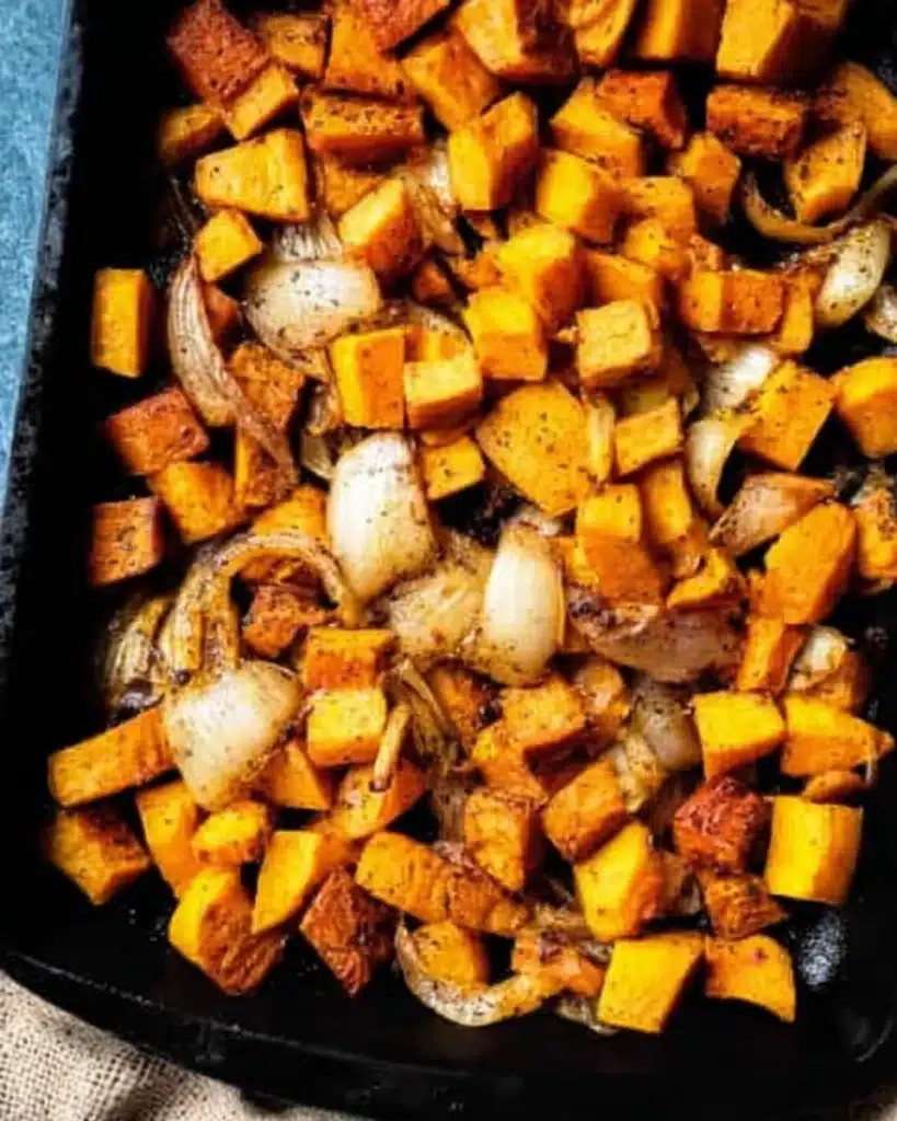 Spicy Butternut Squash and Sweet Potato Soup Recipe 3 Chopped butternut squash, sweet potatoes, and onions on a tray for roasting