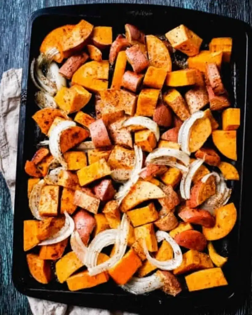 Spicy Butternut Squash and Sweet Potato Soup Recipe 2 Chopped butternut squash, sweet potatoes, and onions on a tray for roasting